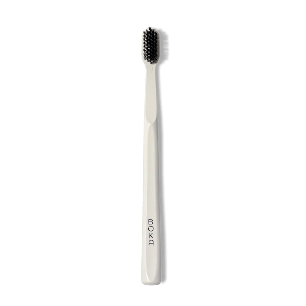 Classic Toothbrush with activated charcoal bristles; BOKA logo printed on white handle.